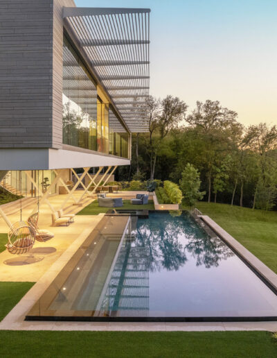 Long pool in backyard of modern home.